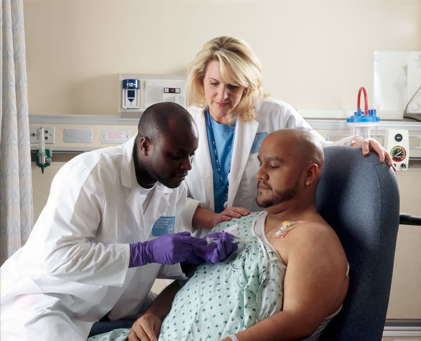 A physician and nurse caring for a patient during treatment