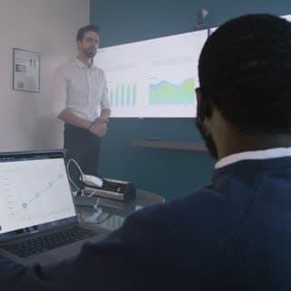 A presenter addressing a diverse leadership team
